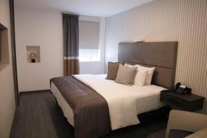 een hotelkamer met een groot bed en een raam bij HUNICO HOTEL in Tulancingo
