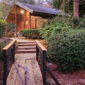 une passerelle en bois menant à une cabine avec bancs dans l'établissement Complejo Rural Los Pedregales Estepona, à Estepona