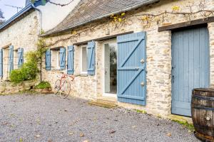 Pannecé的住宿－Charmante Longère À La Campagne，一座带蓝色门的房子和一辆自行车停放在外