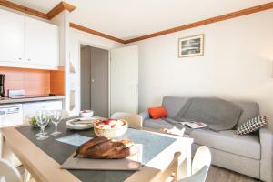 a kitchen and living room with a table and a couch at Résidence Pierre & Vacances Les Bergers in L'Alpe-d'Huez