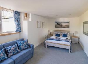 Un dormitorio con una cama y un sofá azul. en Neptune, en Saundersfoot
