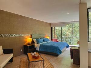 1 dormitorio con cama extragrande y sofá en Mindo Garden Lodge and Wildlife Reserve, en Mindo