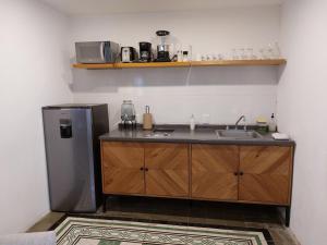 a kitchen with a sink and a refrigerator at Casa Monarcas - Sophia (with AC) in Guadalajara