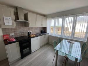 a small kitchen with a table and a glass table top at Beau Vallon Holiday Apartments in St Pierre du Bois