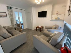 a living room with two couches and a tv at Beau Vallon Holiday Apartments in St Pierre du Bois