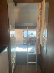 マルベーリャにあるAndalusian Lifestyleのトレーラー内の二段ベッドが備わる小さな客室です。