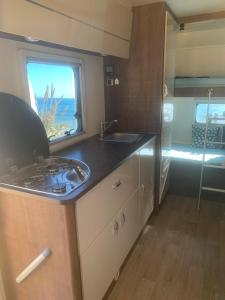 una cocina con fregadero y una ventana en una caravana en Andalusian Lifestyle en Marbella