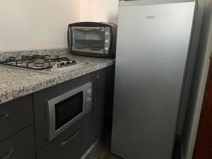 een keuken met een magnetron en een koelkast bij MODERNE APPART PLEIN CENTRE in Fès