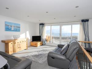 a living room with a couch and a television at 21 Min Y Mor in Pwllheli