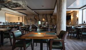 a restaurant with wooden tables and chairs and a bar at Aparthotel Vila San in Kopaonik