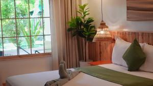 um quarto com uma cama com uma luz pendente e uma janela em Senare Boracay Hotel em Boracay