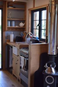 a kitchen with a stove and a sink at The Flying Scotsman Shepherd's Hut with Hot Tub in Brecon