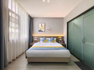 1 dormitorio con 1 cama con almohadas azules y amarillas en Xian Feng Hotel - Tianfu International Airport Branch en Tszyan'yan