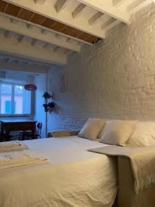 ein Schlafzimmer mit einem großen Bett mit Ziegelwand in der Unterkunft La Casa della Torre in Pisa