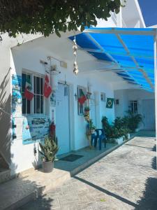Albergo El Pulpo, Bayahíbe في باياهيب: بيت ابيض بأبواب زرقاء وسقف ازرق