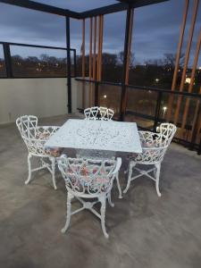 een witte tafel en stoelen op een balkon bij La Plaza MONOAMBIENTE in Sunchales +4 foto's