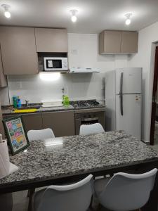 a kitchen with a table with chairs and a refrigerator at La Plaza in Sunchales