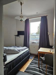 Un dormitorio con una cama y un escritorio y una ventana. en Köln Vermietung Schwermer, en Colonia