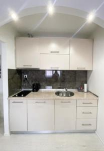 a kitchen with white cabinets and a sink at Apartman Tijana in Pale