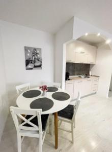 a white kitchen with a white table and chairs at Apartman Tijana in Pale