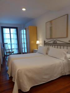 a bedroom with a large bed with white sheets at Apartamento céntrico en Ezcaray in Ezcaray +12 photos