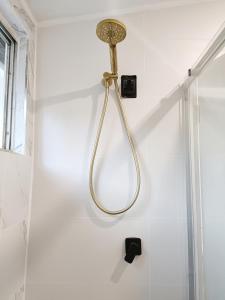 a shower head hanging on a wall in a bathroom at Stunning Queen Room 1Min Walk to Station with 55 Inch TV in Sydney