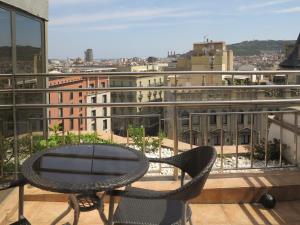 Una mesa y sillas en un balcón con vista. en Serennia Exclusive Rooms, en Barcelona