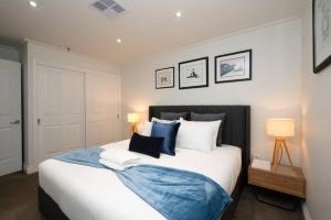 ein Schlafzimmer mit einem großen Bett mit blauen und weißen Kissen in der Unterkunft Gordons Place Entire Apartment CBD Location in Melbourne