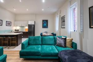 ein Wohnzimmer mit einem grünen Sofa und einer Küche in der Unterkunft Gordons Place Entire Apartment CBD Location in Melbourne