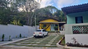 une voiture blanche garée devant une maison dans l'établissement Flat Recanto da Natureza 02, à Cabo de Santo Agostinho