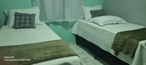 - deux lits assis l'un à côté de l'autre dans une pièce dans l'établissement Flat Recanto da Natureza 02, à Cabo de Santo Agostinho
