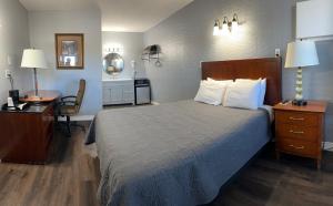 a hotel room with a bed and a desk and a chair at Pelican Motel in Pelican Rapids