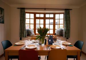 a dining room table with chairs and a large window at Newell Cottage in Seaview