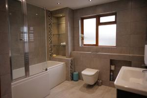 a bathroom with a tub and a toilet and a sink at Newell Cottage in Seaview