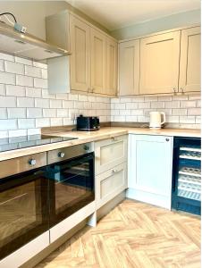 a kitchen with white cabinets and a stove top oven at Castle Rise in Hull