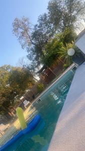 uma piscina com um remo e uma prancha de aogie em Casa los Laureles em Pilas