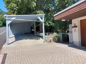a garage with awning next to a building at Wohnung zum Wohlfühlen beruflich und privat in Zell am Main