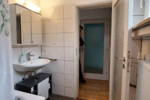 een witte badkamer met een wastafel en een spiegel bij Wohnung zum Wohlfühlen beruflich und privat in Zell am Main