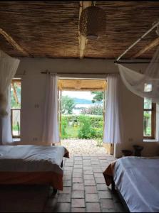 a bedroom with two beds and a large window at INZU Lodge in Gisenyi