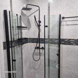 um chuveiro com uma porta de vidro na casa de banho em ,,APARTAMENT W DUSZNIKACH,, em Duszniki Zdrój