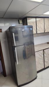 a refrigerator sitting in a room with a wall at Sharing motel rooms in Abu Dhabi