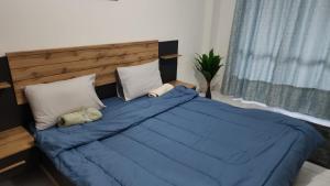 uma cama com um edredão e almofadas azuis em Sharing motel rooms em Abu Dhabi