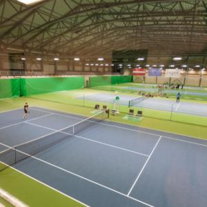 a tennis court with two people on the court at StagHorn floating river house in Jūrmala