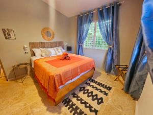 1 dormitorio con 1 cama y una ventana con cortinas azules en Be Inspired at Villa Artistas!, en Arroyo Grande