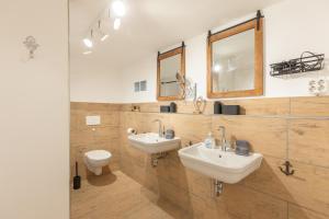 een badkamer met 2 wastafels en een toilet bij Juwel am Deich in Emmelsbüll-Horsbüll +34 foto's