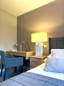 a hotel room with a bed and a desk with a lamp at Castle Rise in Hull