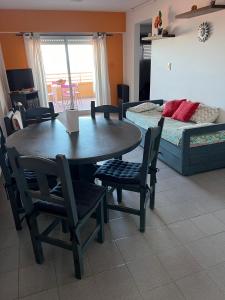 a living room with a table and chairs and a bed at Departamento Libra XX Frente al mar! Promos primavera! in Villa Gesell