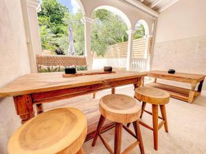 un grande tavolo in legno con sgabelli in una stanza di Villa Oh La La, 250m from the beach, 2 bedrooms a Orient Bay