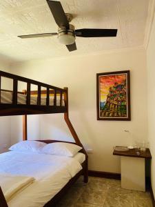 a bedroom with a bed and a ceiling fan at Casa Mano de Tigre in Potrerillos