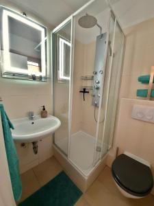 a bathroom with a shower and a toilet and a sink at Long Stay Appartement Kiel in Kiel